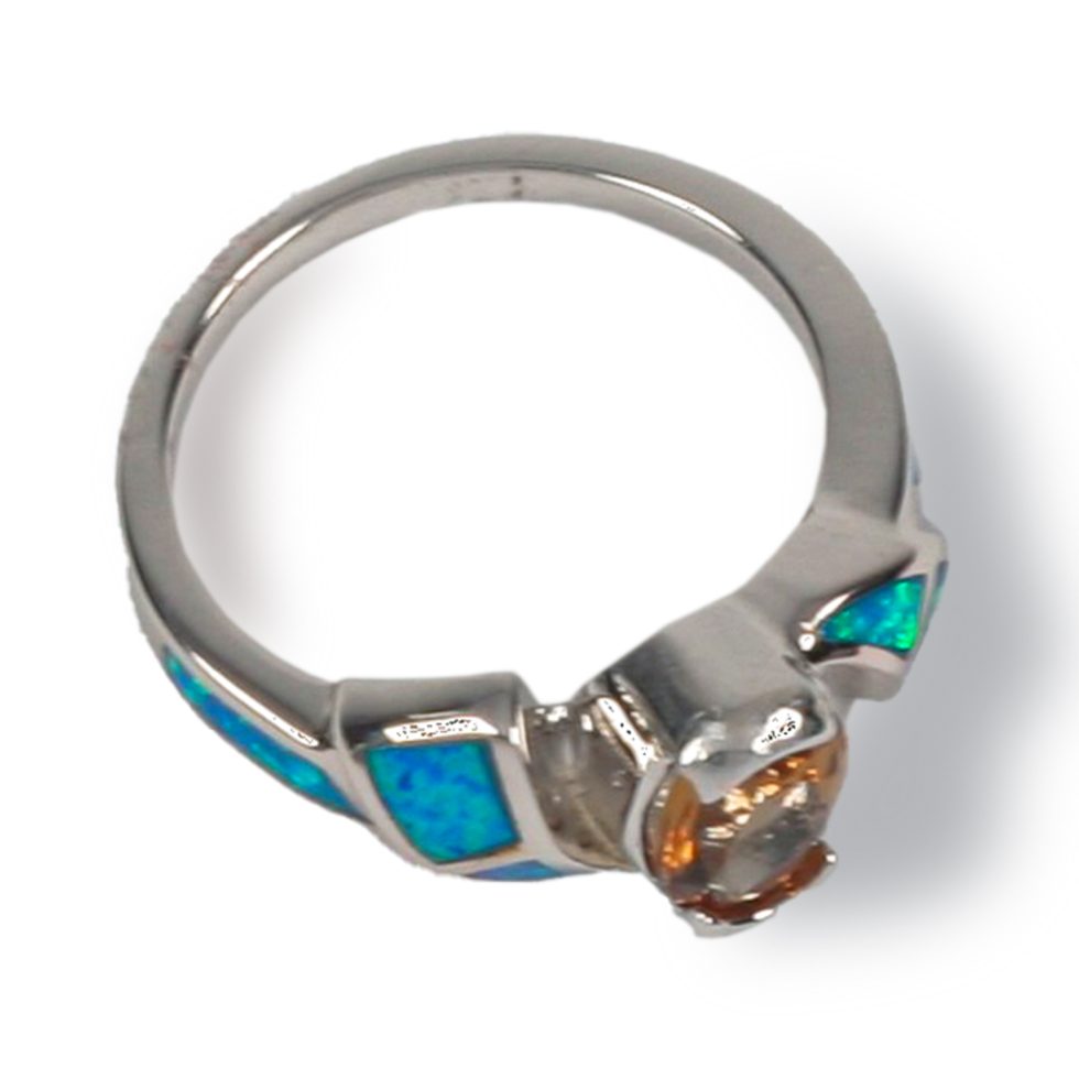 Half-bezel set with staggered “fin” shaped design on each side of center stone with two triangle shaped opal sections in each fin with long opal section down side of shank
